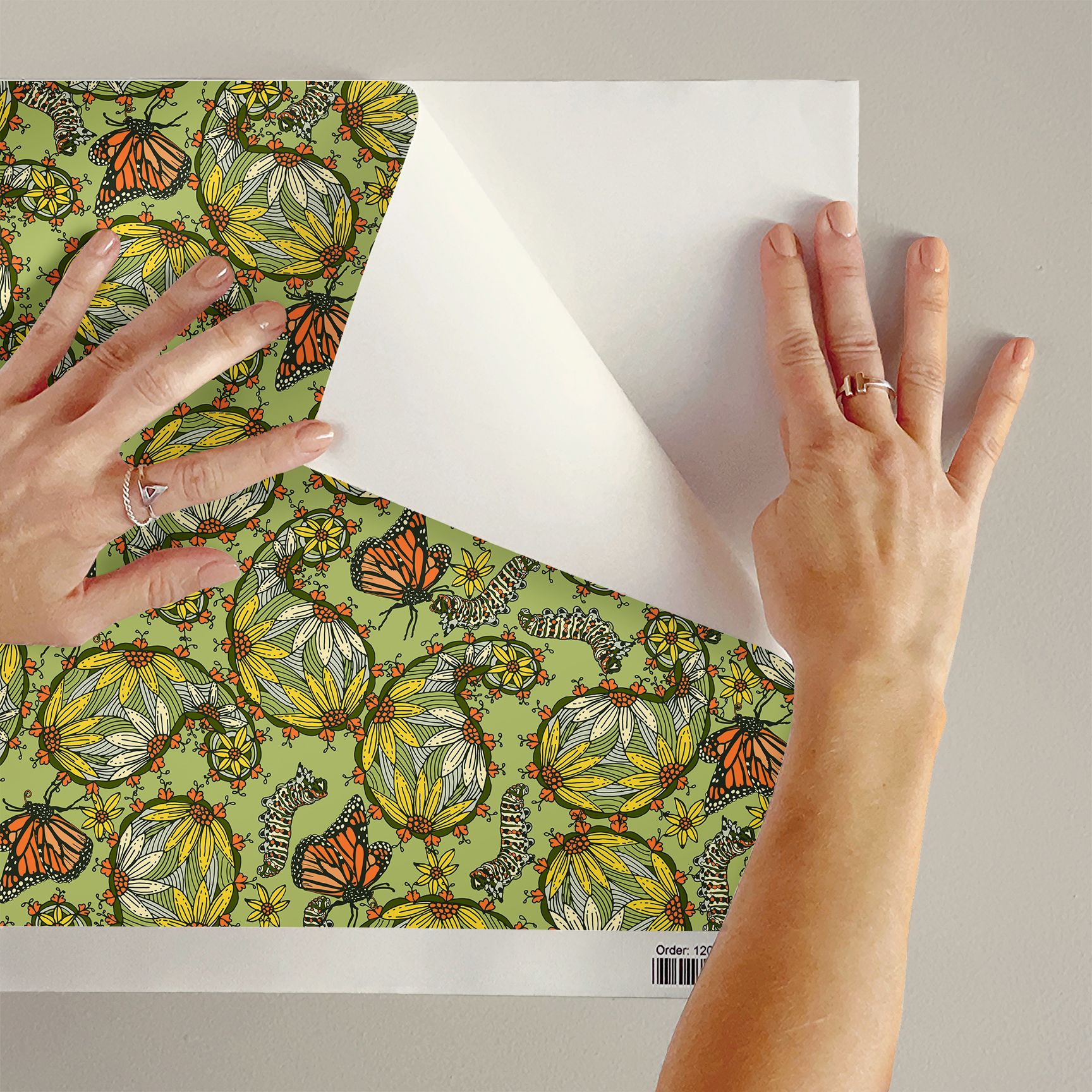 The artwork features a dense, seamless pattern composed of intricately detailed butterflies, caterpillars, and flowers. The butterflies are primarily orange with black and white accents, conveying a monarch butterfly design. The caterpillars are segmented and textured with earthy tones of green and beige, blending naturally with the floral elements. The flowers have petals colored in shades of pale pink and green, with leaves interspersed throughout the composition. The background is a light, muted yellow, which enhances the vibrant colors of the butterflies and floral motifs. The overall design is highly decorative and organic, showcasing a lyrical interplay between the stages of a butterfly's life cycle and plant life.