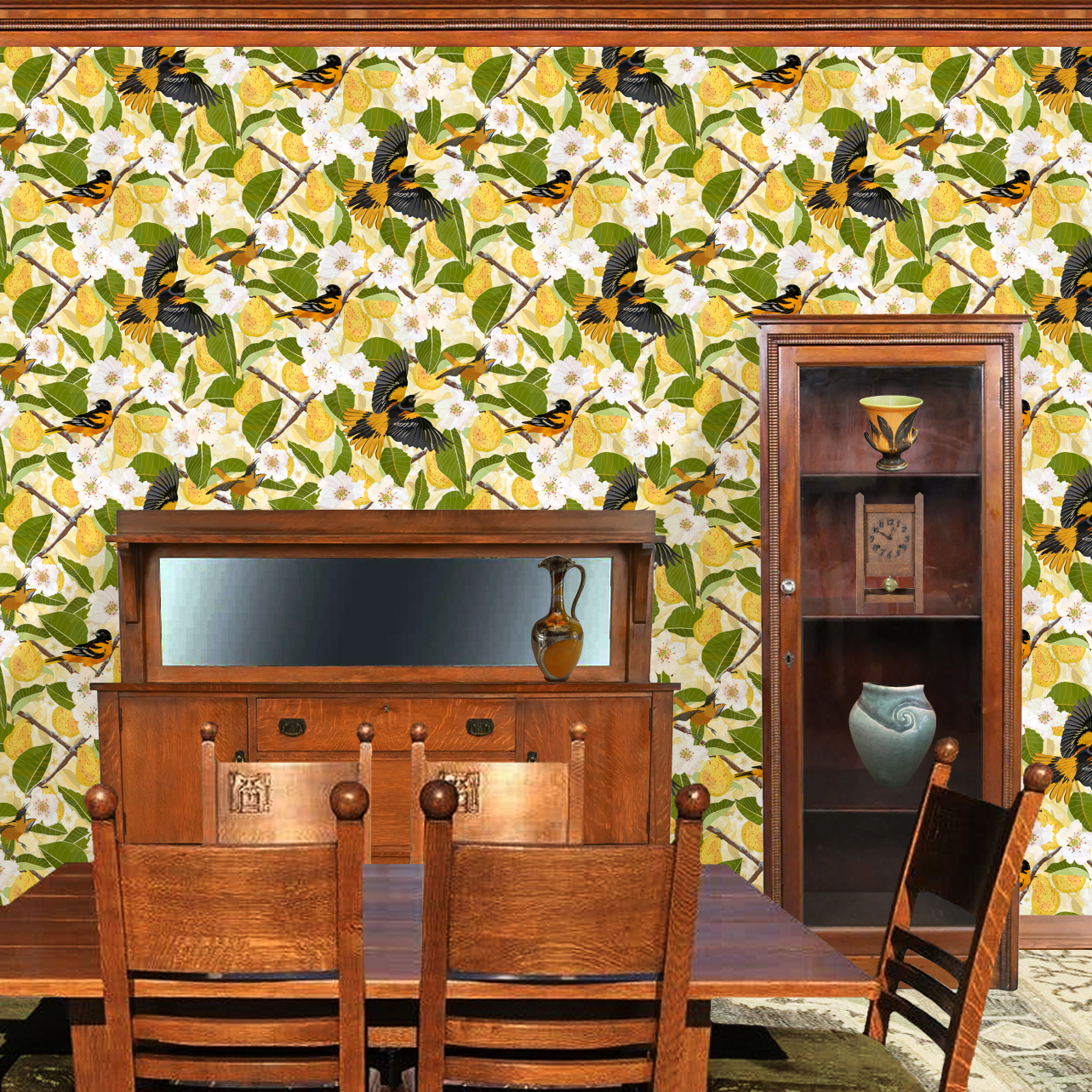 The artwork showcases a vibrant and detailed pattern featuring three orange and black birds set against a backdrop of yellow pears, green leaves, and white blossoms. The birds are depicted in different poses: one perched on a branch, one in mid-flight with wings spread, and another near a pear. The rich colors and intricate details of the feathers, fruits, and flowers create a lively and harmonious composition. The overall style combines naturalistic elements with a decorative, repeating design, highlighting the beauty of nature with emphasis on bold contrasts and vivid hues. The wallpaper design is shown in a Mission style dining room.