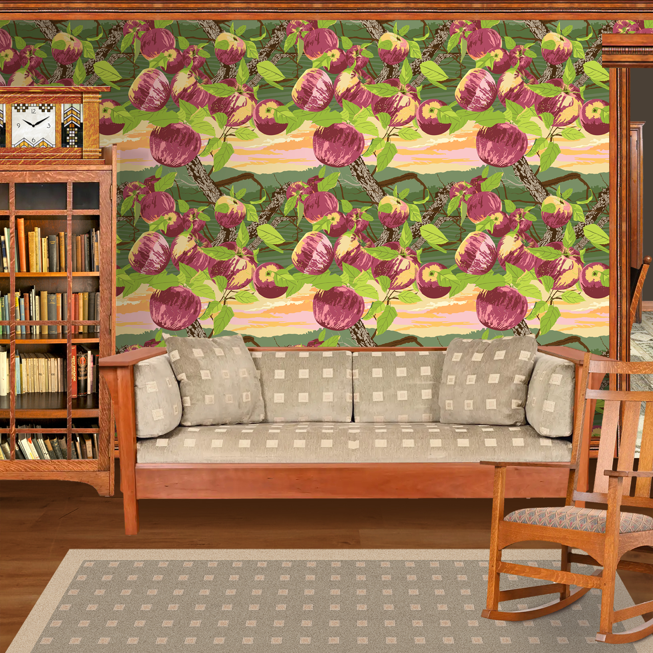 The artwork is a vibrant and stylized depiction of a peach tree with multiple ripe peaches hanging from its branches. The peaches are rendered in shades of pink, purple, and cream, with green leaves surrounding them. The tree trunks and branches are detailed with textured bark in shades of brown. The background features a layered landscape in green hues with a sunset sky colored in gradients of orange, pink, and yellow. The wallpaper design is shown in a Mission style living room